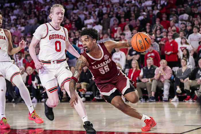 Alabama Crimson Tide guard Aaron Estrada dribbles past Georgia Bulldogs guard Blue Cain.
